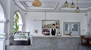a woman is standing behind a counter in a kitchen at My BanLao Hotel in Luang Prabang +272 photos