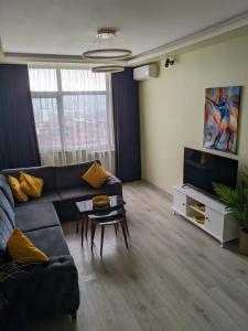 Una sala de estar con un sofá y un televisor en Двухкомнатная кватира с видом на горы, en Batumi