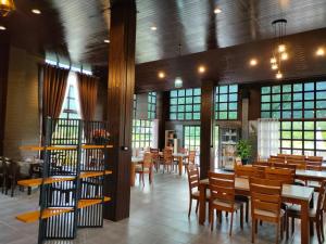 a restaurant with wooden tables and chairs and windows at Mountain Deer Resort & Camping in Ban Mung