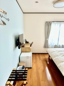 une chambre avec un lit et une télévision sur un mur dans l'établissement 蔵の宿, à Kamogawa