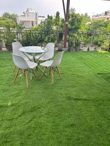 a table and chairs sitting on the grass at Cosy and Comfortable Cottage in South Delhi in New Delhi