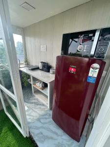 a kitchen with a refrigerator with a microwave on top at Cosy and Comfortable Cottage in South Delhi in New Delhi