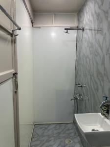 a bathroom with a shower and a sink at Cosy and Comfortable Cottage in South Delhi in New Delhi +4 photos