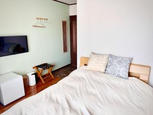 a bedroom with a bed and a tv on a wall at 蔵の宿 in Kamogawa