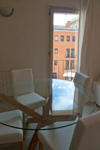ジローナにあるPou Rodóの窓付きの客室で、ガラスのテーブルと椅子が備わります。