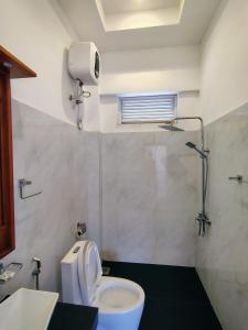 une salle de bain avec toilettes, lavabo et fenêtre dans l'établissement Sinharaja Tea Garden Hotel, à Rakwana 46 autres photos