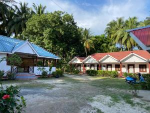une rangée de maisons avec des arbres en arrière-plan dans l'établissement Dream Valley Resort, à Neil Island