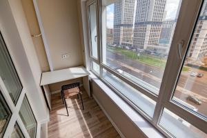Un escritorio y una silla en una habitación con ventana. en Freedom, en Astana