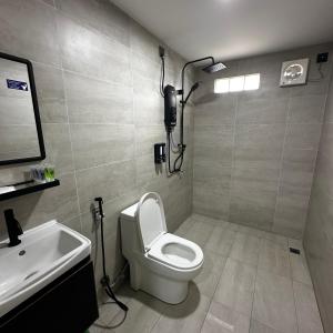 a bathroom with a white toilet and a sink at Orchid Cabin Kuala Tahan in Kuala Tahan