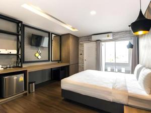 a bedroom with a large white bed and a tv at The Circle Hotel in Ban Bu Lamduan +88 photos