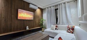 a living room with a white couch and a tv at Le Casablanca in Maarif +2 photos