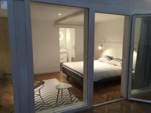 a bedroom with a bed and a glass window at Gîte Le Temple - Appart Hôtel in Verdun-sur-Meuse