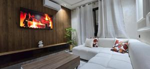 a living room with a white couch and a tv at Le Casablanca in Maarif