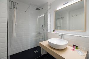a white bathroom with a sink and a mirror at B&B HOTEL Apartamentos Madrid Centro Fuencarral 46 in Madrid +37 photos