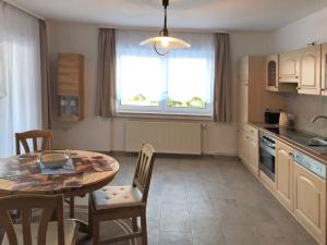 une cuisine avec une table et des chaises et une fenêtre dans l'établissement Cozy Apartment in Ellar with Garden, à Ellar