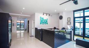 a restaurant with a bar with a person sitting at it at The Bed Hotel Phitsanulok in Sathani Phitsanulok