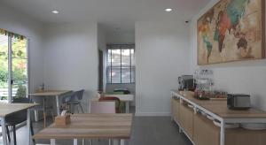 une cuisine avec des tables et un tableau mural dans l'établissement Oh My Place, à Chiang Rai