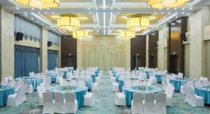 a banquet hall with blue and white tables and chairs at Hundred Hotel Qingdao in Qingdao