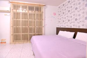 a bedroom with a large bed and a window at 法頌休閒民宿 in Dongshan