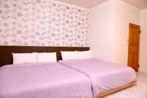 two beds sitting next to each other in a bedroom at 法頌休閒民宿 in Dongshan +1 photo