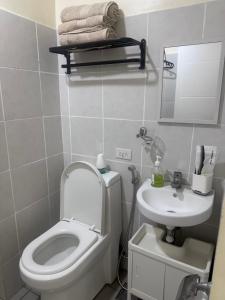 ein Badezimmer mit Toilette und Waschbecken in der Unterkunft Northwoods Place Condominium Unit1026 in Mandaue City + 6 Fotos
