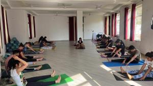 a group of people sitting in a yoga class at The Ajna Resident Rishikesh in Rishīkesh