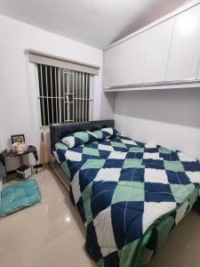 a bedroom with a bed with a blue and white comforter at Kira Villa in Tlekung +4 photos