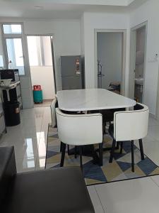 a dining room with a white table and white chairs at Alstenor Homestay 2 in Kajang