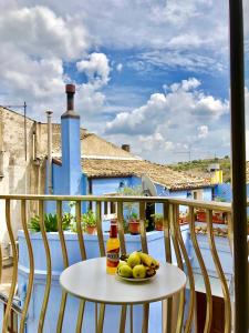 a table with a bottle of beer and fruit on a balcony at Accommodates 5 people between Ibla and Ragusa in Ragusa +65 photos