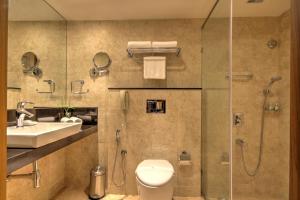 a bathroom with a shower and a toilet and a sink at Dolphin Hotel in Visakhapatnam
