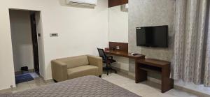 une chambre d'hôtel avec un lit et un bureau avec une télévision dans l'établissement Gachibowli, Santoshi Krupa, à Hyderabad 5 autres photos