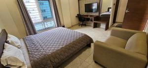 une chambre avec un lit, un canapé et un bureau dans l'établissement Gachibowli, Santoshi Krupa, à Hyderabad