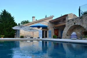 a swimming pool with two umbrellas and a house at Villa sur Golf Opio Valbonne in Opio