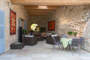 a patio with a table and chairs and a stone wall at Villa sur Golf Opio Valbonne in Opio