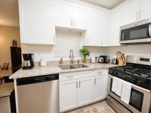 a kitchen with white cabinets and a stove top oven at Premier Resort Style Living Minutes from Santa Monica in Los Angeles