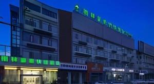 a building with a green sign on top of it at GreenTree Inn Yancheng Yandu District Hongxing Macalline Century Avenue in Ti-pa-yung