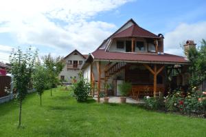 ein Haus mit einem Pavillon im Hof in der Unterkunft Motel Fogado in Cristuru Secuiesc