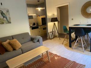 a living room with a couch and a table at logement avec accès piscine in Chaumont-sur-Tharonne