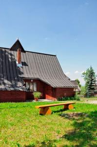 a building with a bench in front of it at Pokoje u Bobików in Ząb