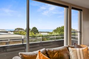 un soggiorno con divano e ampie finestre di Manna Heaven Luxury Coastal Retreat with Pool a Torquay