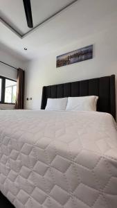 - un grand lit blanc avec une tête de lit noire dans la chambre dans l'établissement Newport Hotel, à Atimpoko 24 autres photos