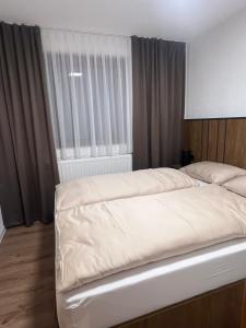 ein Schlafzimmer mit einem großen Bett mit Fenster in der Unterkunft Villa Apartments Mirela in Vlasic