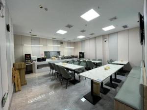 a large room with tables and chairs and a kitchen at GreeTree Inn Suzhou Industrial Jinji Lake Xinhujie Gaojiaoqu in Suzhou