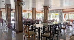 ein Esszimmer mit einem langen Tisch und Stühlen in der Unterkunft Hihotel Saraburi in Ban Rong Saeng