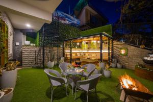 Un patio con mesa y sillas y una chimenea. en The Walnut Stays, en Solan