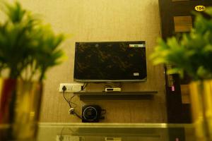a flat screen tv sitting on a wall at Alphineglow Hotel in Yercaud
