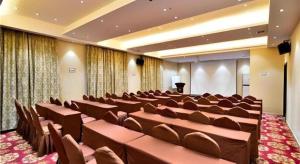 une salle de conférence avec des chaises brunes et un podium dans l'établissement City Comfort Inn Kunming Cuihu Hospital of Yunnan University Panjiawan Metro Station, à Kunming