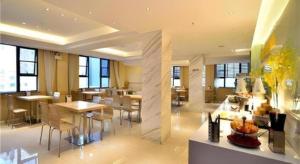 une grande chambre avec des tables et des chaises dans un bâtiment dans l'établissement City Comfort Inn Kunming Cuihu Hospital of Yunnan University Panjiawan Metro Station, à Kunming