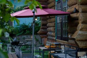 今津Forest Villa Ilio Biwako的露台上摆放着一把粉色遮阳伞，还有桌椅