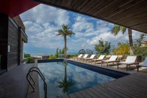 einen Pool mit Liegestühlen und Meerblick in der Unterkunft Erhai Lake Seclusion Life in Dali